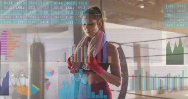 Kadın boksör havluyu ortada tutarken vücut geliştirme grafikleriyle ısınıyor. Boks, spor salonu, atlet, kadın, eğitim, odaklanma, dinamik