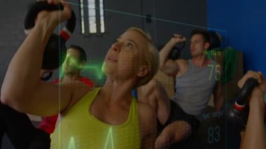 Kettlebell 'i grupla canlandıran ve kaldıran bir kadın, ECG güncellemesi ve kalp atışını başlatan bir sağlık elemanı. Fitness, spor salonu, katılımcılar, zil, kaplama, biyometrik, stüdyo