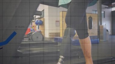 Koşu bandındaki son sınıf kadın elinde protez tutarak yürüme mesafesini kaplayan rehabilitasyon grafiklerine başlıyor. Ampüte, hareketlilik, rehabilitasyon, spor salonu, vr, kaplama, biyomekanik