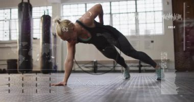 Kadın yüksek tahtalara başlıyor, yan tahtaya dönüyor, HUD ölçü ve grafikleri takip ediyor. Spor salonu, çekirdek, denge, güç, atletik, stüdyo, çantalar