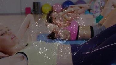 Dersi takip eden kadınlar, beden eğitimi dersinde mavi minderlere basanlar, karın kasları üzerinde titreşen dünya. Grup, stüdyo, spor salonu, çekirdek, rutin, takım çalışması, canlı