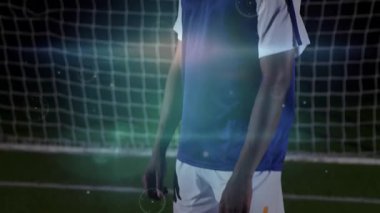 Erkek futbolcu kalede topu takip ediyor, oyunu kontrol etmek için göğsünü kaldırıyor, işaret fişeği takip ediyor. Sporcu, promosyon, sinema, spor, gece, stadyum, kararlılık