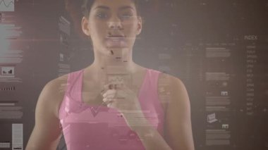 Kadın sağ elini kaldırıyor, göğsüne vuruyor, yapay zeka grafiklerinin yüz ve gövde üzerinde kaydığını gösteriyor. Holografik, gösterge paneli, arayüz, eşleşmeler, sunucu, stüdyo, şeffaf