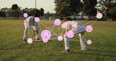 İki erkek oyuncu topa vuruyor, tokmak sallıyor, çim oyunu oynuyor, AR ağı topa doğru ilerliyor. Açık hava, park, çimen, altın saat, eklenti, ikili, spor giyim