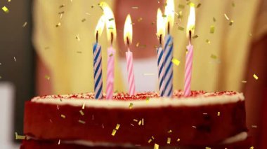 Altın konfetisi pasta düşerken beş mum, çakmak tutarken fönü hazırlamak için yaklaşıyor. Kutlama, beklenti, şenlik, sıcak, mutfak, dekor, sim
