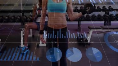 Kadın kıvrımları başlatıyor, dambılı kaldırıyor ve form kontrol ederken fitness takip çubuğu çizelgelerini örtüyor. Jimnastik, ağırlık, bank, ayna, egzersiz, analitik, odaklanma