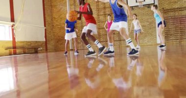 Erkek oyuncu kırmızıyla boyaya çarpıyor. Kazak alıyor. Animasyon yay takip topu spor için çembere doğru gidiyor. Basketbol, mahkeme, spor salonu, takım çalışması, rekabet, gençlik, savunma