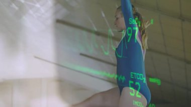 Yavaş tava jimnastikçisi kolları dengeleyerek spor telemetrisi yansıtma ölçümlerini dengeliyor. Sporcu, jimnastik salonu, yalın ayak, duruş, uzatma, okuma, üst üste bindirme