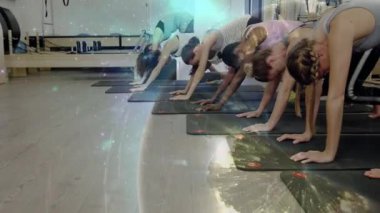 Yoga yapan çocuklar gibi poz veren kadınlar. Galaksi hasırlar ve dinlenen bedenler arasında akıyor. Grup, fitness, gerilme, stüdyo, hizalama, sakin, döşeme