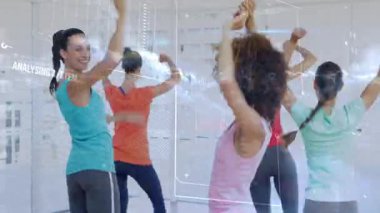 Beş kadın antrenörlük yapıyor, kollarını kaldırıyor, fitness 'de dönüşüyor, HUD kaplaması grup üzerinde tamamlanıyor. Spor, koreografi, dans, stüdyo, ayna, gün ışığı, renkli