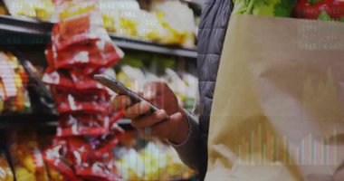 Adam elinde kağıt torba, sağ tarafında çizgi film çizelgeleri tutarken telefonunu dinliyormuş. Süpermarket, tüketici, mobil, analitik, kaplama, üretim, kereviz