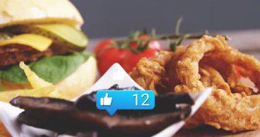 Kabarcık sayısı gibi mavi, başparmaklar yükselirken hamburger içe dönük kameralar gibi gelişiyor. Sandviç, patates kızartması, soğan halkası, mantar, domates, yeşillik, ahşap.