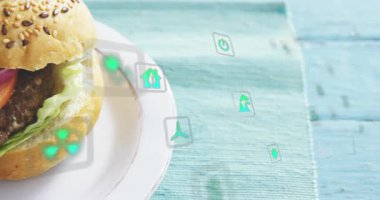 Kamera geri çekiliyor, yeşil simgeler sol çapraz plakaya sürükleniyor, hamburgerler vitrin dokularını gösteriyor. Hamburger, susam, köfte, domates, soğan, marul, turkuaz.