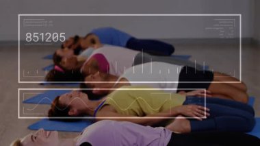 Yoga koçu başlıyor, grup minderlerin üzerinde nefes alırken HUD bisiklet dalga formlarını sükunet için örtüyor. Stüdyo, katılımcılar, fitness, rahatlama, hizalama, dinginlik, dijital