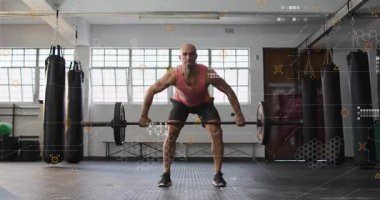 Erkek asansör bacakların arasından geçiyor, halteri çekiyor ve çeviriyor, güç kazanmak için başınızın üstüne tutunuyor. Kap, halter, spor salonu, patlayıcı, güç, antrenman, atlet