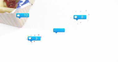 Paket servis kutusu kayıyor, hamburger ve patates kızartması gösteriyor, yumurtlayan rozetler, popülerliğini gösteren sayılar artıyor. Sandviç, yemek, susam, pastırma, damalı, masa üstü, viski.