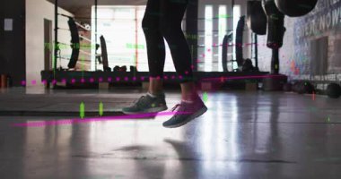 Stajyer spor salonunda hoplayıp zıplıyor, kamera yükselirken bacaklarının üzerinden kayan animasyon şamdan çizelgesi. Atlama, halat, atlet, dinamik, kardiyo, antrenman, ağırlık