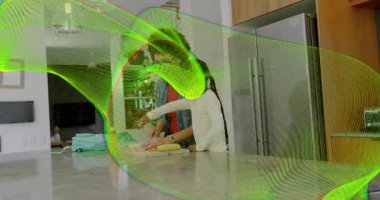 Bakıcı kız ellerini kesme tahtasına koyuyor, yeşil kaplama hareket ederken yemek yapmayı öğretiyor. Mutfak, ada, muz, narenciye, hazırlık, aile, öğrenme