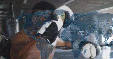 Boksör halata yaslanmış eldiven kaldırıyor gardiyan dinlenirken dünya haritası onu örtüyor. Boks, atlet, spor salonu, ter, dayanıklılık, odak, endüstriyel