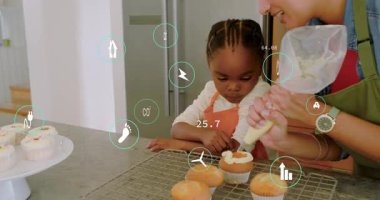 Yetişkin rehber çocuk ve sıkma torbası, şekerli kekler, pişirme öğretmek, AR simgeleri havada süzülmek. Bakıcı, çocuk, mutfak, tezgah, el bilgisayarı, öğrenme, etkileşimli