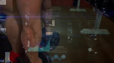 Dambıl tutan erkek stajyer, yedek kulübesinde uzanıyor, fitness çizelgeleri gücü takip ederken bastırıyor. Ağırlıklar, spor salonu, odaklanma, temsilciler, dinamik, grafikler, analitik