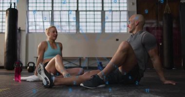 Spor partnerleri setten sonra dinleniyor ve üzerlerinde mavi rakamlarla beşlik çakarak antreman yapıyorlar. Sporcular, fitness, sakinlik, dostluk, gün ışığı, stüdyo, kettlebell