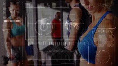 Mavi elbiseli kadın, kıvırcık saçlı, spor salonunu bitiren kamera içeri giriyor, el bilgisayarı analiz formu hazırlıyor. Çalışma, ağırlık, halter, plaka, gözcü, odaklanma, kararlılık