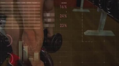 Adam dambıllara uzanıyor, sırt üstü uzanıyor ve baskı yapıyor. Ağırlıklar, spor salonu, bank, güç, eğitim, cesaret, kararlılık