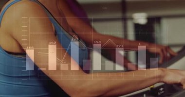 Mavi elbiseli kadın kemeri tutuyor ve kemer takıyor. Fitness istatistikleri takip ediyor, partnerini açığa çıkarıyor. Koşu bandı, spor salonu, kardiyo, ikili, odaklanma, motivasyon, dayanıklılık