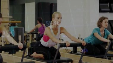 Eğitmen şeftali tanklı kadın, yenilikçiyi zorluyor, pilates formu için omurgasını açıyor ve hizalıyor. Spor, grup, esneme, stüdyo, hareket, aynalar, sağlık