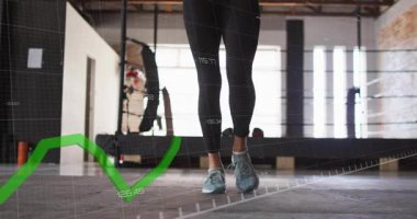 Spor salonunda hoplayıp zıplayan bir kadın ayak hareketlerinin yoğunluğunu ölçmek için yeşil grafik kullanıyor. Fitness, antrenman, kardiyo, arka ışıklandırma, stüdyo, atletik, veri