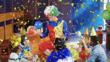 Çocukların partisinde mavi balon gösteren palyaço kalabalığın arasında altın konfetilerin patlamasına neden oluyor. Gösterici, kostüm, renkli, çocuklar, kutlama, dekor, fon