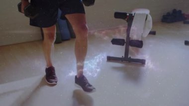 İnsan ağırlığını değiştiriyor ve dambıllarla ileri atlıyor. Galaksi işaret fişeği formunda formda. Hamle, ağırlık, kürek, ev spor salonu, dağınık ışık, odaklanma, fitness