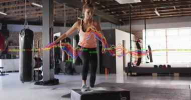 Atletin adım atması, adımlar atması ve bacak güç dalgası senkronizasyonunu dengelemesi. Fitness, antrenman, reklam, istikrar, güç, spor salonu, stüdyo