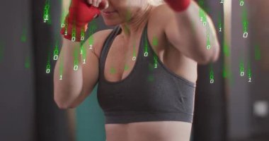 Kamera yakınlaşması olarak boks için kırmızı ambalajlı kısa yumruklar atan bir kadın yeşil ikili sisteme neden oluyor. Sporcu, boksör, spor salonu, stüdyo, odaklanma, kararlılık, dayanıklılık