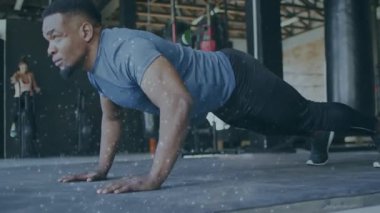 Yüksek tahtadan başlayan yavaş şınav çeken bir adam canlandırmalı sayaç izleme formundayken. Sporcu, depo, spor salonu, sanayi, minder, güç, eğitim