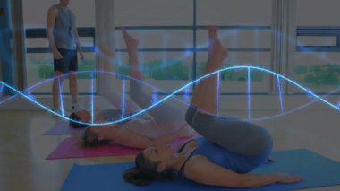 Mavi elbiseli bir kadın, mavi bir dalga boyu spor salonunda bacaklarını ters çeviriyor. Yoga, stüdyo, paspas, eğitmen, denge, esneklik, güneş ışığı