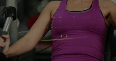 Çekici kolları olan ve göğüs baskısı yapan bir kadın, ilerlemeyi takip ederken finans tablolarını örtüyor. Spor, spor, spor, güç, eğitim, makine, üst üste bindirme