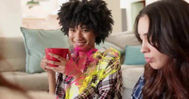 Kırmızı kupa yudumlayan kıvırcık saçlı kadın ve pazarlama için uzun saçlı arkadaşı sarmaya başlayan pembe girdaplı kadın. Arkadaşlar, ev, renkli, gülümseyen, rahat, rahat, fincan