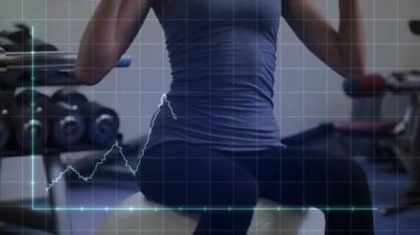 Spor topuna alışan bir kadın, güç için mavi ağırlıklara basarken el sallayarak iz sürme hareketi yapıyor. Fitness, antrenman, dambıl, istikrar, odaklanma, egzersiz, stüdyo