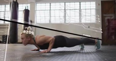 Kadın dirseklerini bükerek spor salonunda şınav çekmeye başlıyor. Zaman çizgisi, fitness hareketini takip ediyor. Jimnastik, sporcu, kalas, temsilci, boks, çanta, pencere