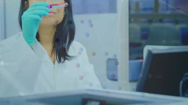 Kafkasyalı kadın doktorun üzerinde test tüpüyle DNA ipliği. Küresel tıp ve dijital arayüz kavramı dijital olarak oluşturulmuş video.