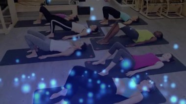 Eğitmen sırasındaki pilates katılımcıları, paspasların üzerindeki leğen kemiğini birleştirmek, hareketli çubuklarla çekirdeği aktive etmek. Zindelik, sağlık, egzersiz, grup, zarafet, güç, uygulama