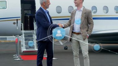 Havalimanında el sıkışan iki beyaz iş adamının dijital simge ağının animasyonu. Küresel ağ ve iş teknolojisi kavramı