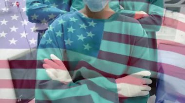 Kamera, ameliyathane ekibinin sağlık birliği gösteren bayraklarla çevrili olduğunu gösteriyor. Tıbbi, takım çalışması, profesyonel, klinik, esneklik, sağlık, birlik