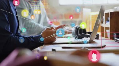 Masadaki akıllı telefonu dinleyen ve dizüstü bilgisayarla dijital ağı eşleyen kullanıcı simgeleri gönderen bir kadın. İşbirliği, bağlantı, teknoloji, iletişim, modern, üretkenlik, yenilik