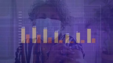 Maskeli bir kadın gözlük takıyor ve çizgi çizelgeleriyle verileri analiz ediyor. Teknoloji, analitik, fütürizm, dijital, veri görselleştirme, zeka, yenilik