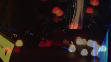 Animation on blurred night road traffic over hands of african american man playing keyboard. Music, entertainment and night city life concept digitally generated video.