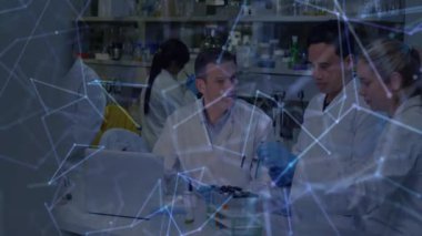 Laboratuvarda numune hazırlama işleminde kaplama zayıflıyor. Bilim adamları pipet yaparken tepsiyi inceliyor. Araştırma, işbirliği, yenilik, teknoloji, bilim, laboratuvar, kesinlik