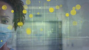 Afro-Amerikan kadın doktor maskesinin üzerinde süzülen sarı noktaların animasyonu. Coronavirus covid 19 salgını sırasında dijital olarak üretilen ilaç, sağlık ve sağlık hizmetleri.